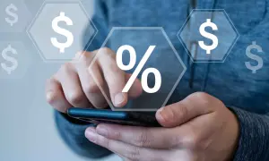 Mani che interagiscono con uno smartphone, con icone di dollari e un simbolo di percentuale che fluttuano, suggerendo il calcolo di cosa sono i premi assicurativi.