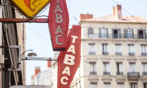 Insegne luminose di un tabaccheria, con la scritta "TABAC" in rosso e bianco. Qui si può acquistare anche una carta prepagata usa e getta.
