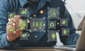 Un uomo interagisce con icone digitali che illustrano il **significato ESG in finanza**: energia solare, auto elettrica, riciclo, CO2, industria e lampadina.