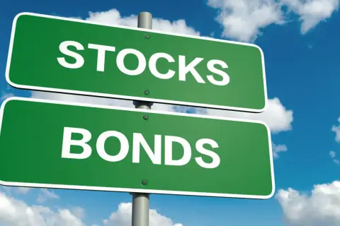 Cartelli stradali verdi indicano "STOCKS" e "BONDS", illustrando la differenza tra azioni e obbligazioni.