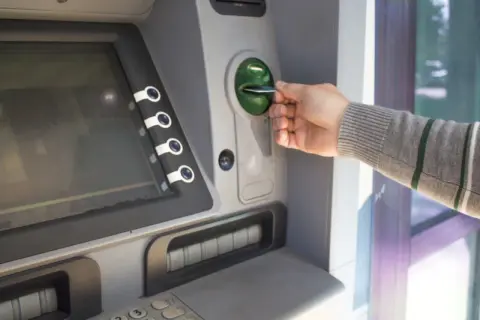 Mano inserisce una carta in un bancomat. Sospetto che il prelievo bancomat non effettuato da me.