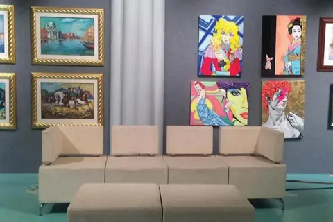 Un salotto moderno con opere d'arte colorate alle pareti, un invito a investire in opere d'arte per arredare con stile.