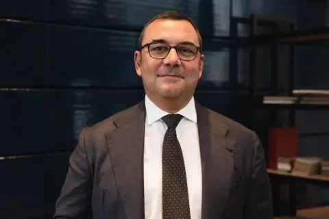 Uomo in giacca e cravatta, con occhiali, che parla di investimenti SRI, definizione e opportunità.