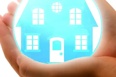 Mani che proteggono una casa stilizzata, simbolo di sicurezza e dei rami assicurativi che tutelano il tuo focolare.