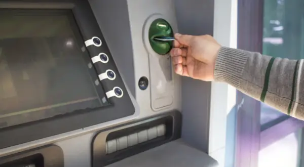 Mano inserisce una carta in un bancomat. Sospetto che il prelievo bancomat non effettuato da me.
