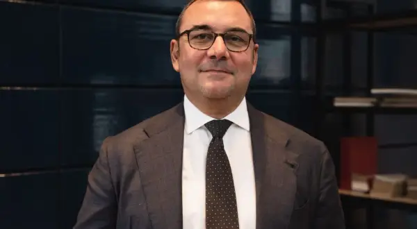 Uomo in giacca e cravatta, con occhiali, che parla di investimenti SRI, definizione e opportunità.