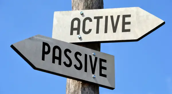 Cartello stradale con frecce che indicano "ACTIVE" e "PASSIVE", una metafora per la gestione attiva e passiva.