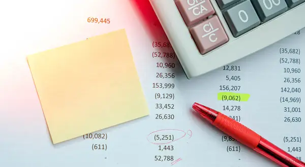 Foglio di calcolo con calcolatrice, penna rossa e post-it. Un esempio di rimborso spese in fattura evidenziato.