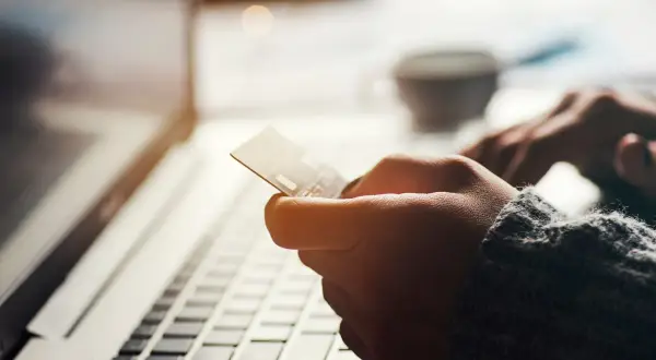 Mano con carta di credito BPER per acquisti online o prelievi all'estero.