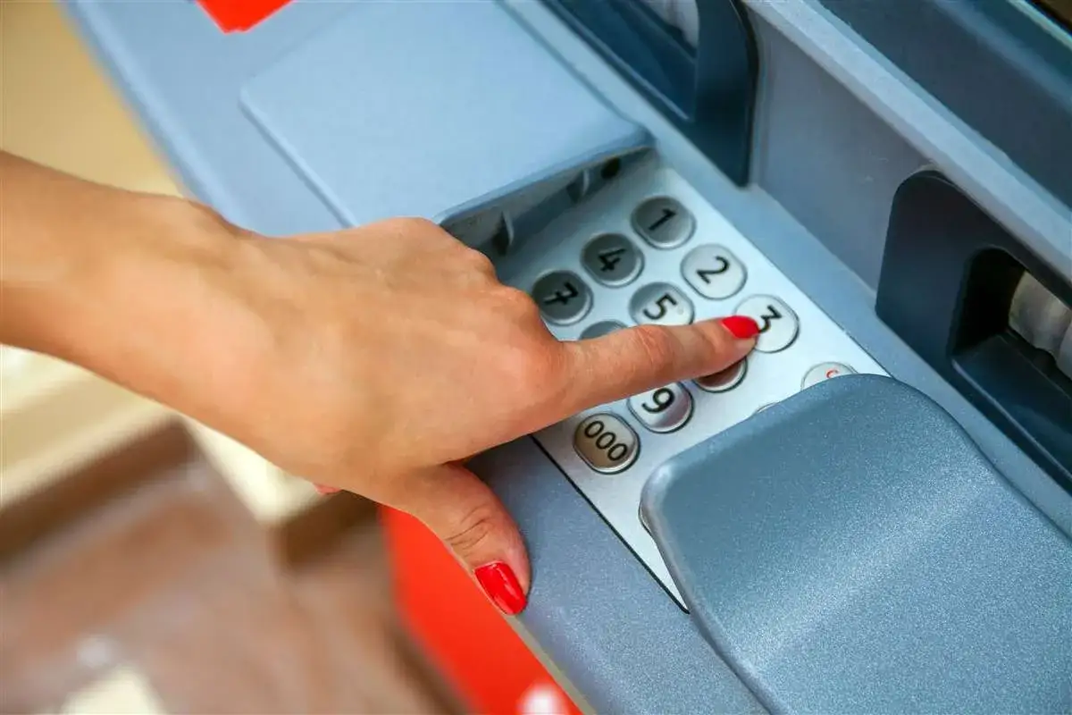 Dito si vede quanto si può prelevare allo sportello, con una mano che digita il codice PIN su un bancomat.