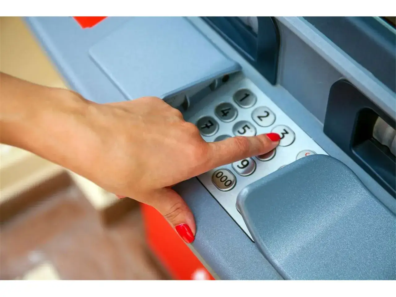 Dita con smalto rosso premono tasti di un bancomat. Sospetto un prelievo bancomat non effettuato da me.