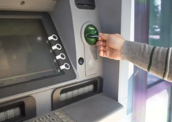 Mano inserisce una carta in un bancomat. Sospetto che il prelievo bancomat non effettuato da me.