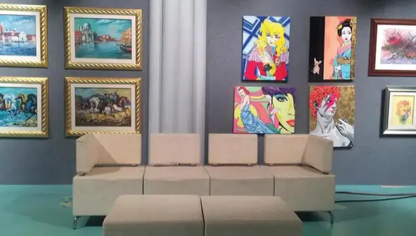 Un salotto moderno con opere d'arte colorate alle pareti, un invito a investire in opere d'arte per arredare con stile.