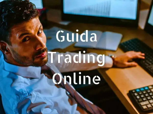 Uomo concentrato davanti a schermi, testo "Guida Trading Online".